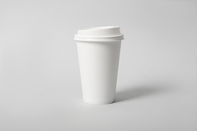 Photo of Takeaway paper coffee cup on light grey background