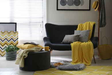 Photo of Comfortable sofa with pillows and plaid in living room. Interior design