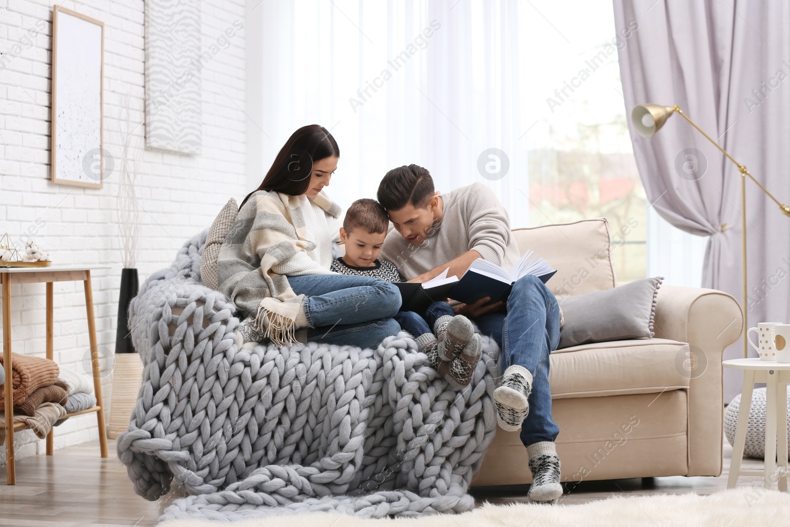 Photo of Happy family with little son reading books at home. Winter vacation