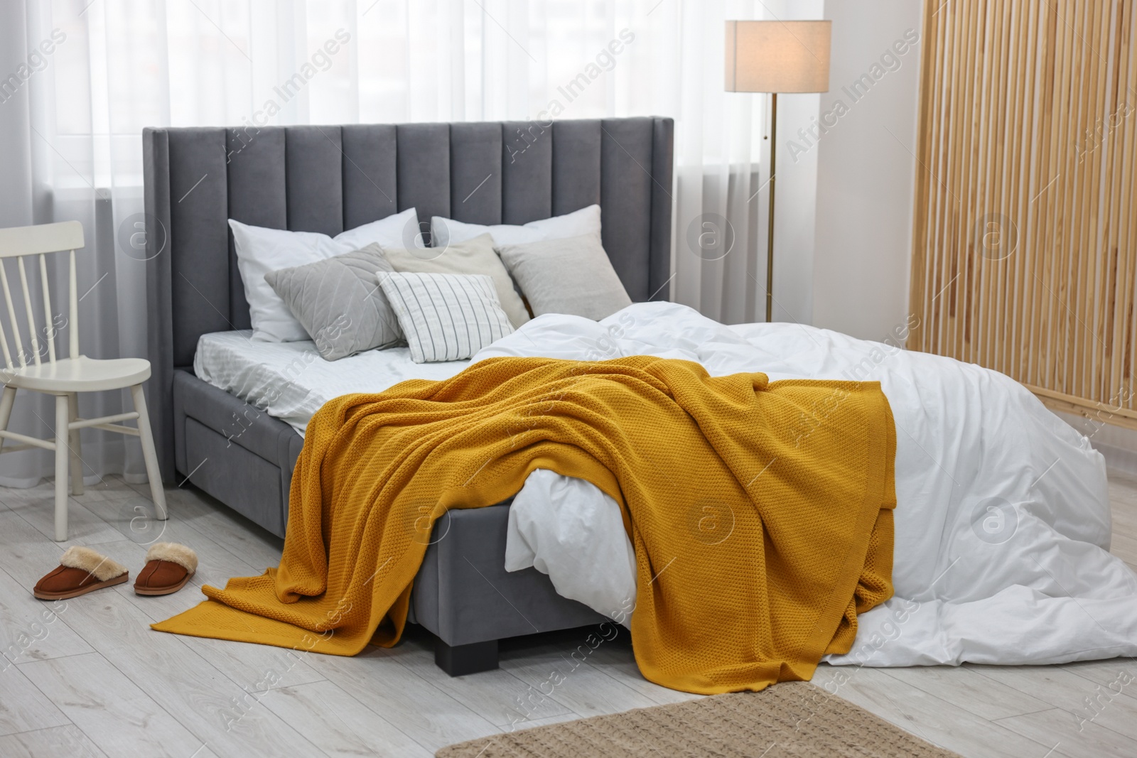 Photo of Bright plaid on bed in stylish bedroom