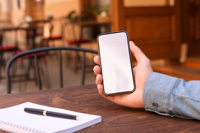 Photo of Man using mobile phone at table outdoors, closeup. Space for text