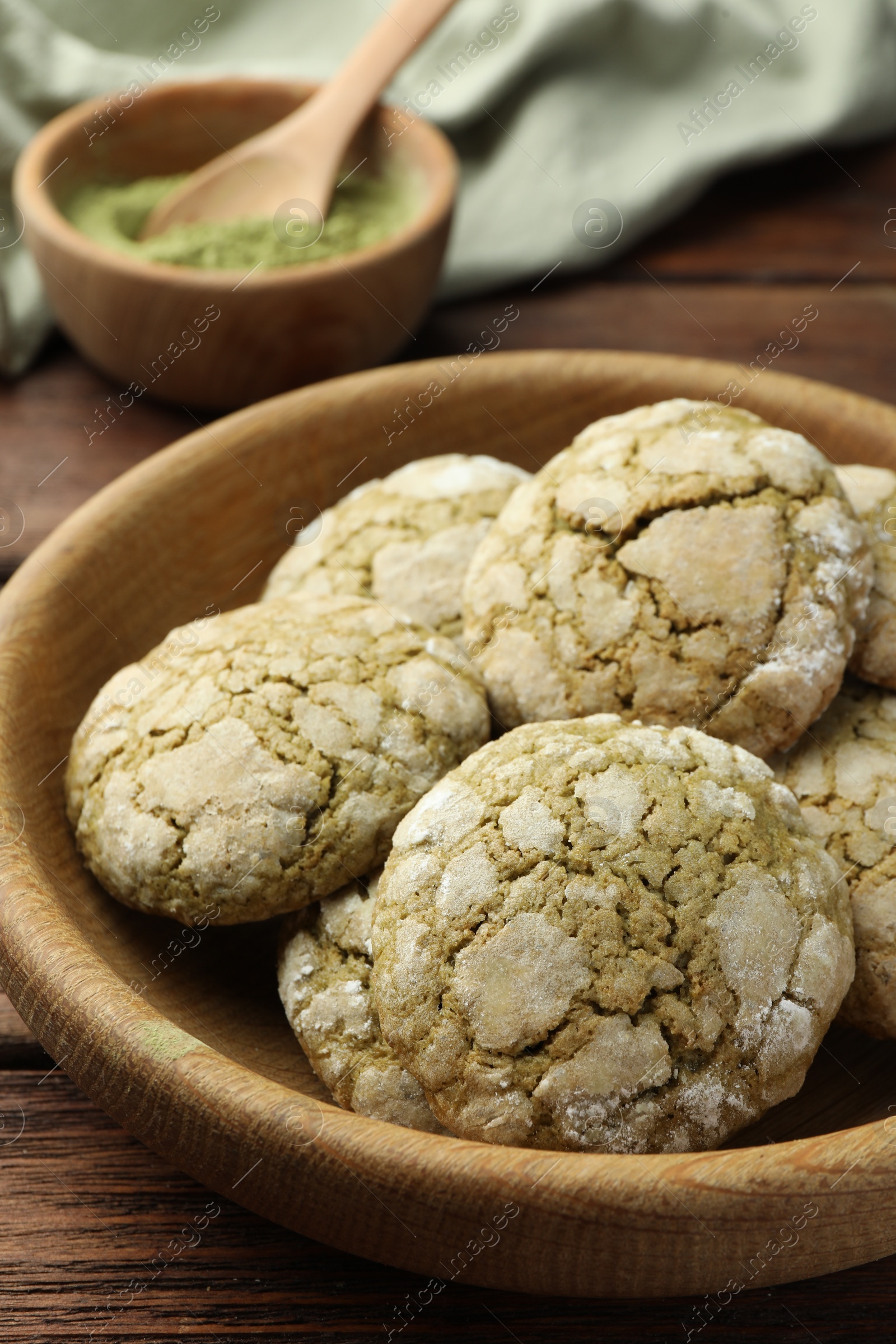 Photo of Bowl with tasty matcha cookies on wooden table, closeup