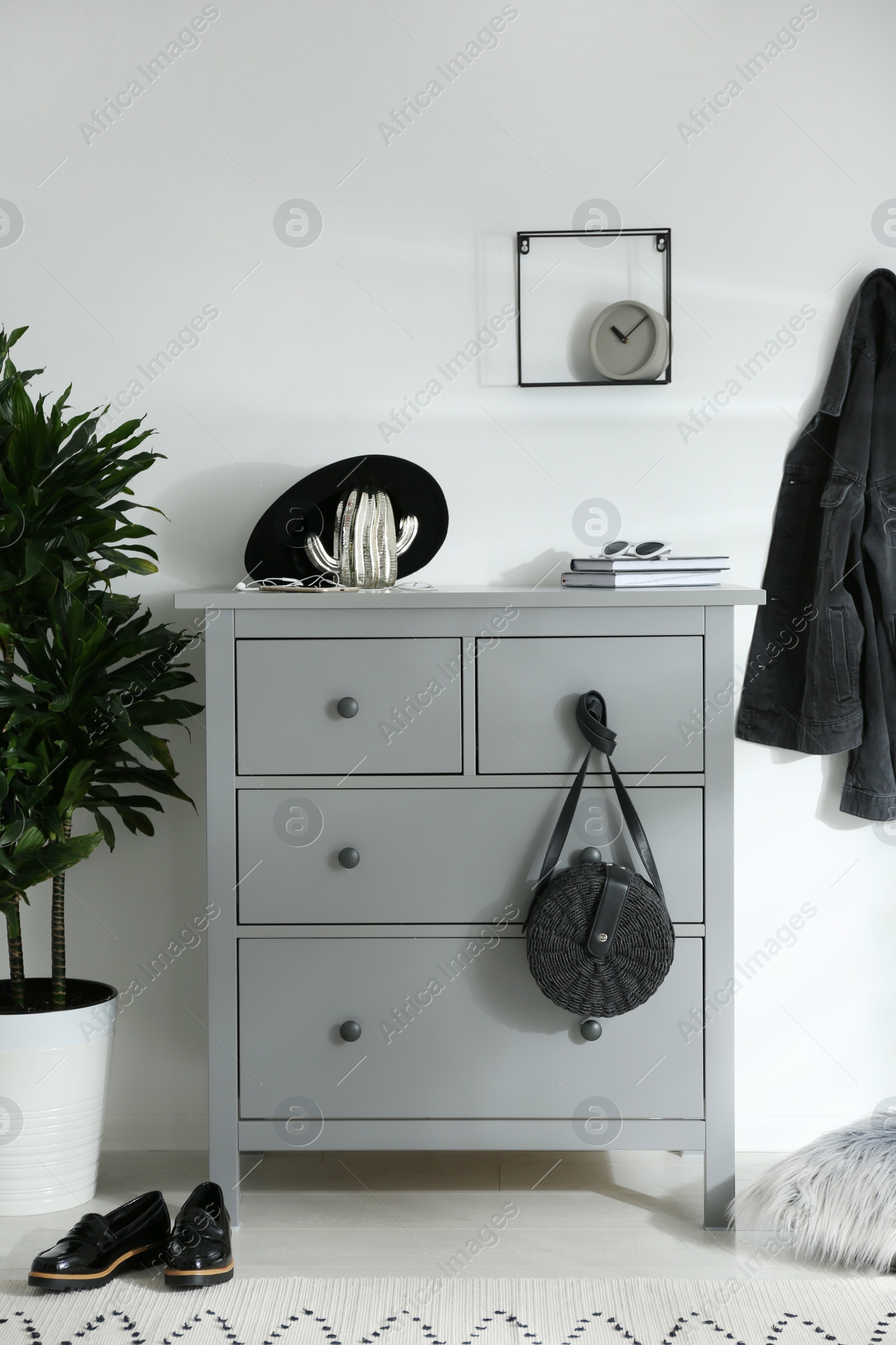 Photo of Grey chest of drawers in stylish room. Interior design