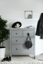 Grey chest of drawers in stylish room. Interior design