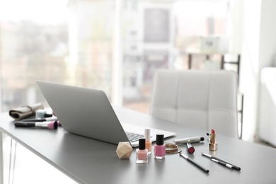 Photo of Makeup products for woman and laptop on table