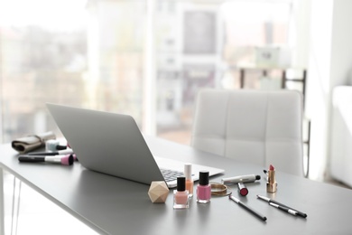 Makeup products for woman and laptop on table