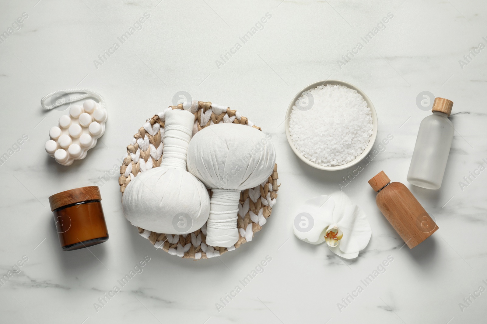 Photo of Flat lay composition with herbal massage bags and other spa products on white marble table