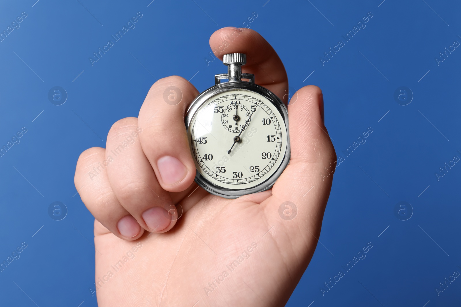 Photo of Man holding vintage timer on blue background, closeup