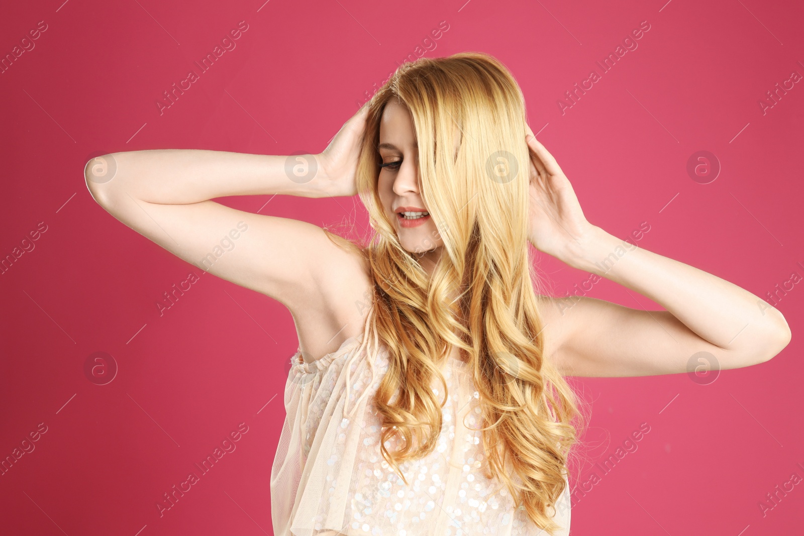 Photo of Portrait of beautiful young woman with dyed long hair on pink background