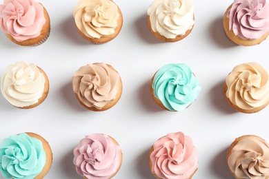 Photo of Flat lay composition with delicious birthday cupcakes on white background