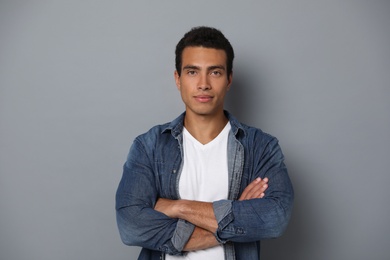 Photo of Handsome young African-American man on grey background