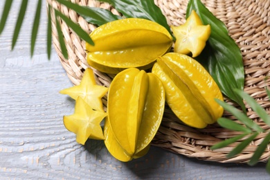 Delicious carambola fruits on light grey wooden table, above view