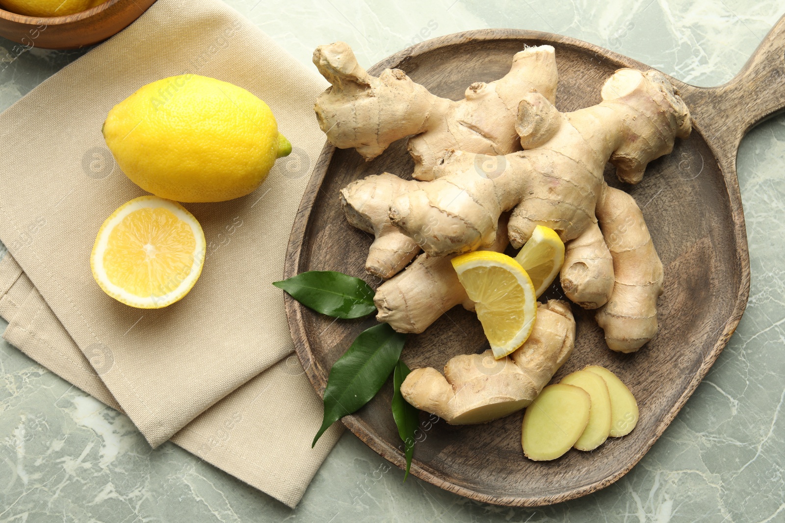 Photo of Fresh lemons and ginger on grey marble table, flat lay