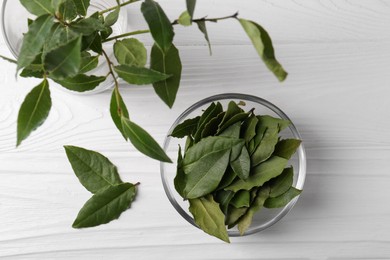 Photo of Fresh green bay leaves on white wooden table, flat lay