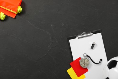 Photo of Different referee equipment on black table, flat lay. Space for text