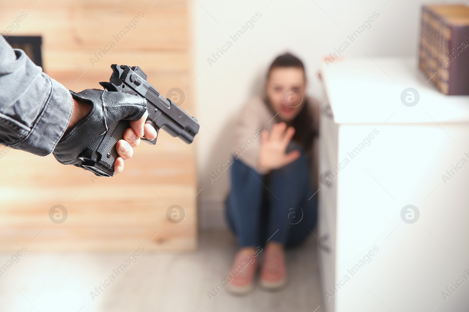 Photo of Man aiming his victim with gun indoors, closeup. Dangerous criminal