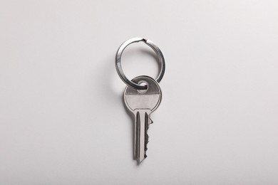 Photo of House key on light grey background, top view. Real estate agent services