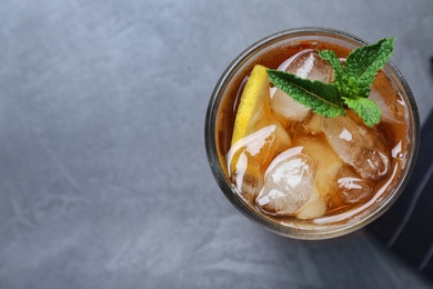 Photo of Delicious iced tea in glass on grey table, top view. Space for text