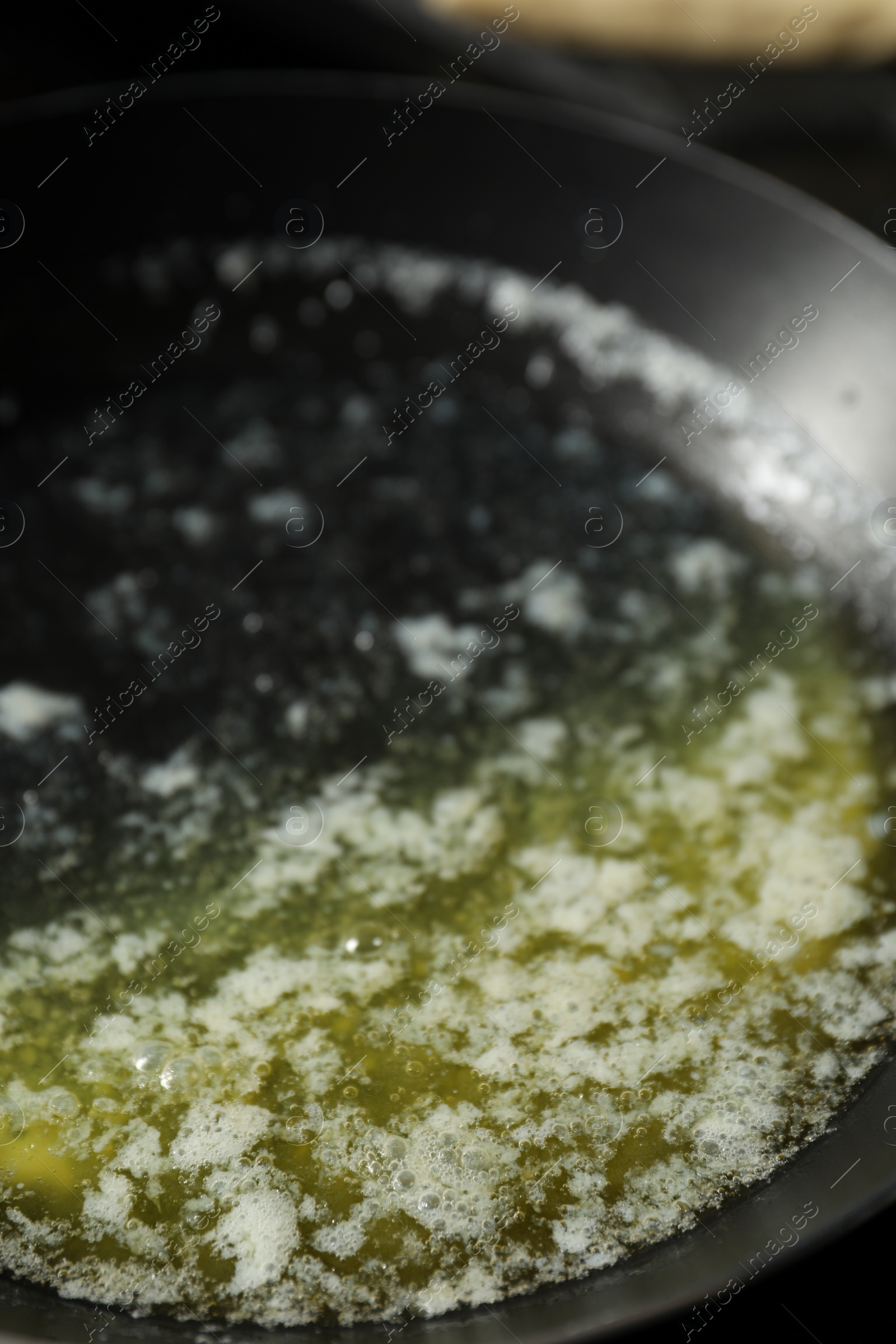 Photo of Melting butter in frying pan, closeup view