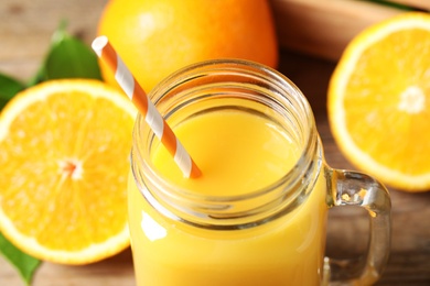 Photo of Mason jar of orange juice and fresh fruits, closeup