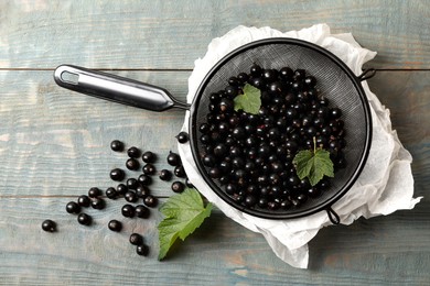 Ripe blackcurrants and leaves on wooden rustic table, flat lay