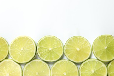 Photo of Fresh juicy lime slices on white background, flat lay. Space for text