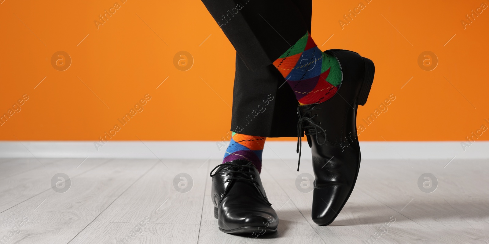 Photo of Man wearing stylish shoes and colorful socks indoors, closeup. Space for text