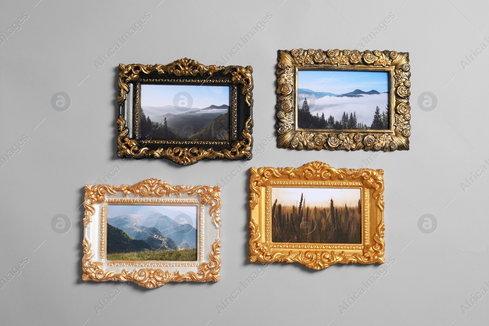 Photo of Vintage frames with beautiful photos of landscapes hanging on light gray wall