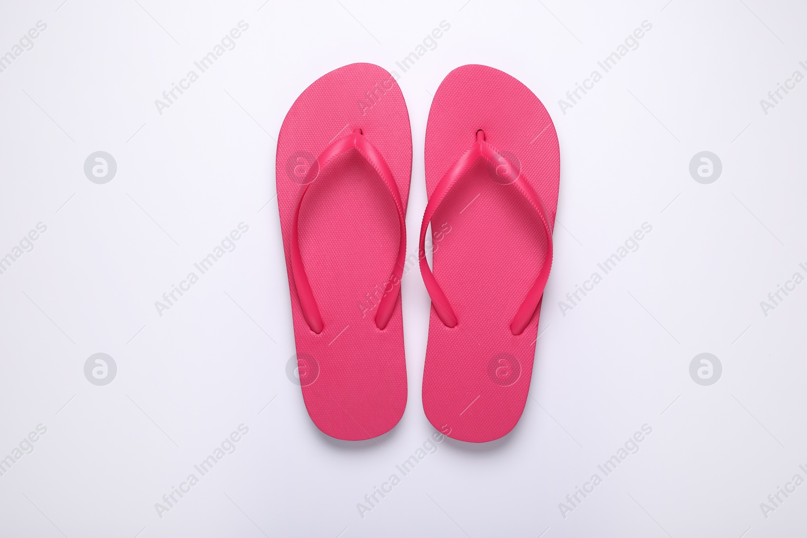 Photo of Stylish pink flip flops on white background, top view