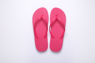 Photo of Stylish pink flip flops on white background, top view