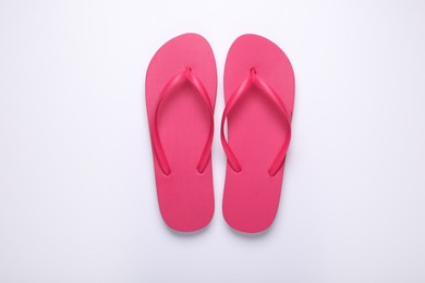 Stylish pink flip flops on white background, top view