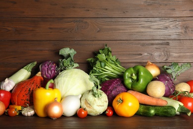 Photo of Many fresh ripe vegetables on wooden background. Organic food