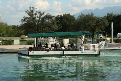 Monterrey, Mexico - September 11, 2022. Tourist boat with people on canal in Parque Fundidora