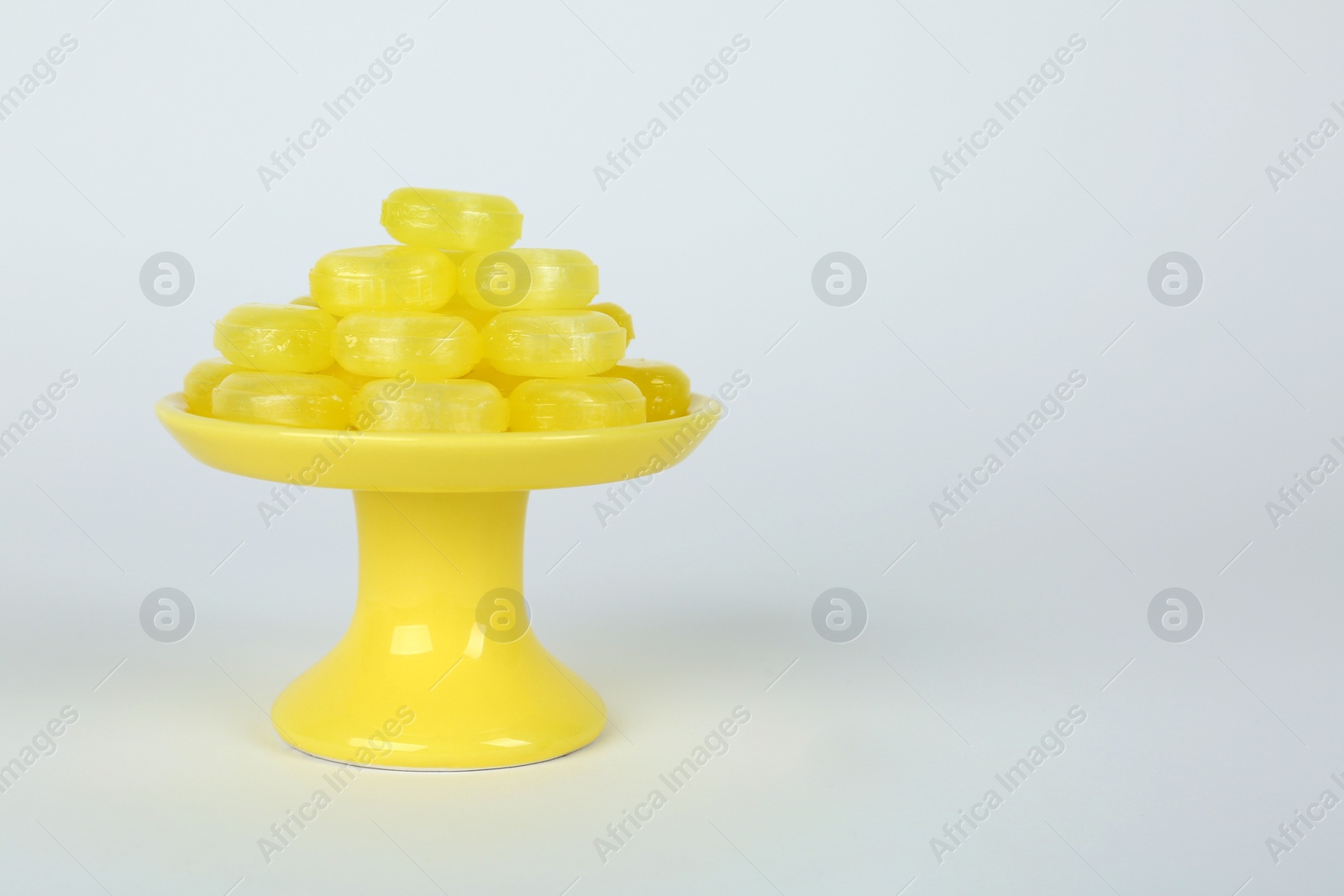 Photo of Tasty small lemon drops on white background