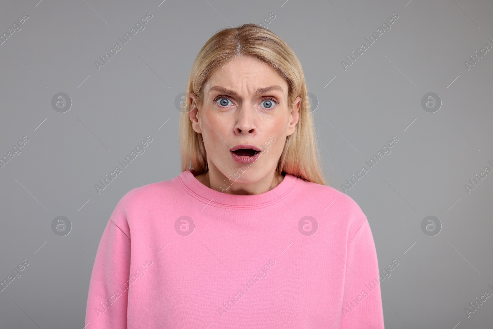 Photo of Portrait of surprised woman on grey background