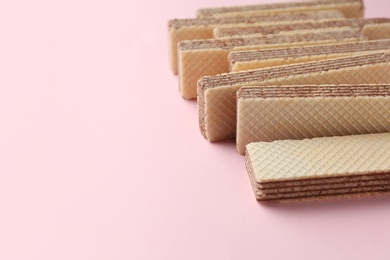 Tasty wafer sticks on pink background, closeup with space for text. Sweet food