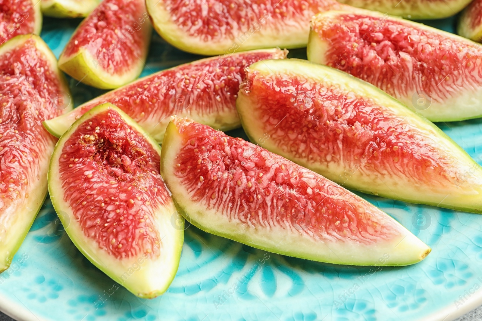 Photo of Fresh ripe fig slices on plate, closeup. Tropical fruit