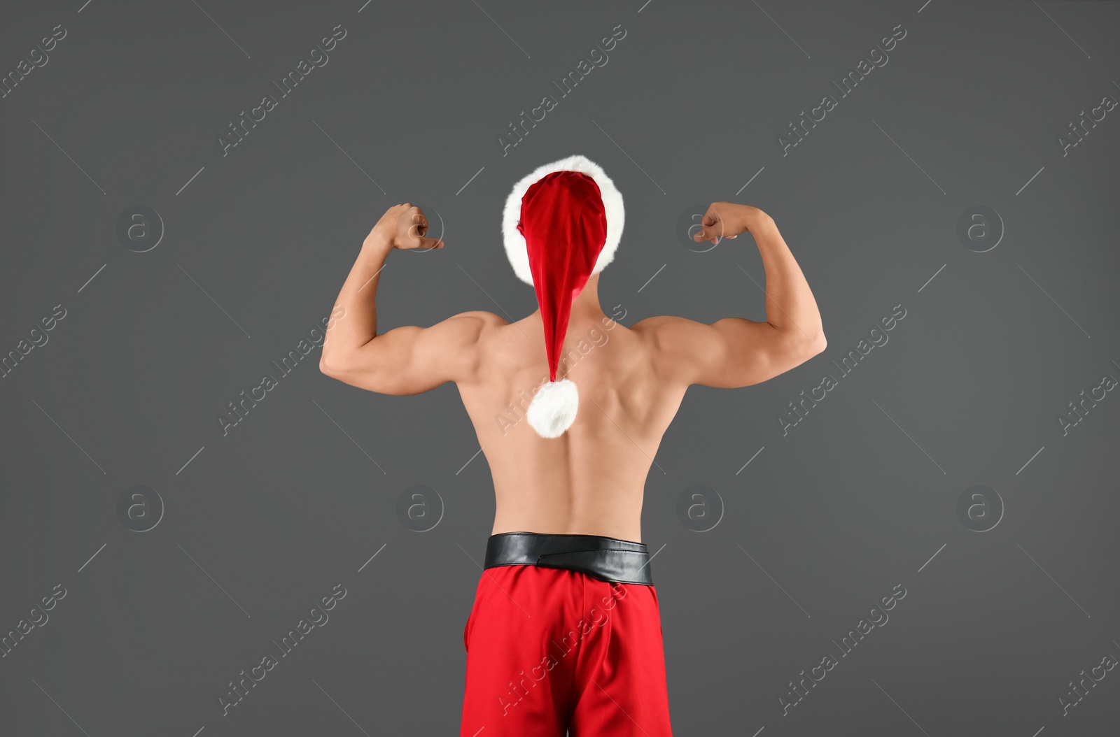 Photo of Shirtless young Santa Claus with sexy body on color background