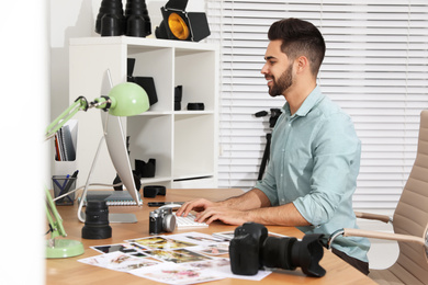 Professional photographer working at table in office