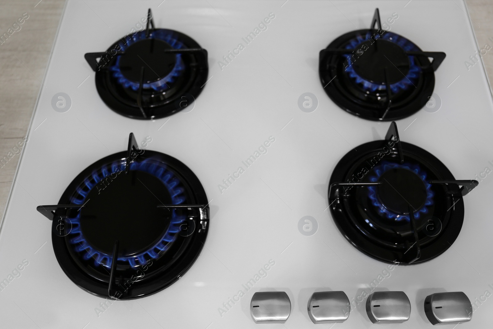 Photo of Modern kitchen stove with burning gas, above view