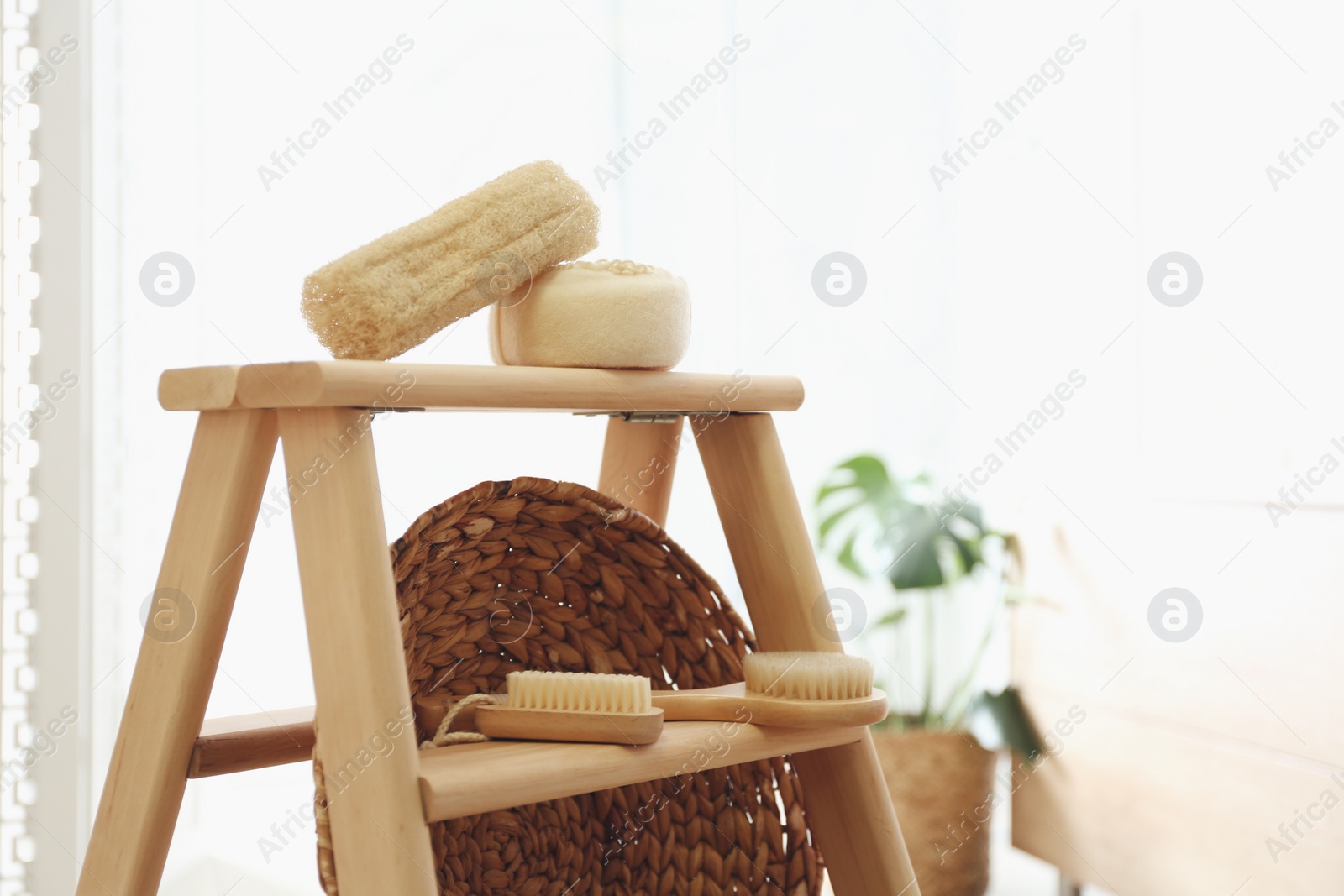 Photo of Dispensers and different toiletries on decorative ladder in bathroom, closeup. Idea for interior design