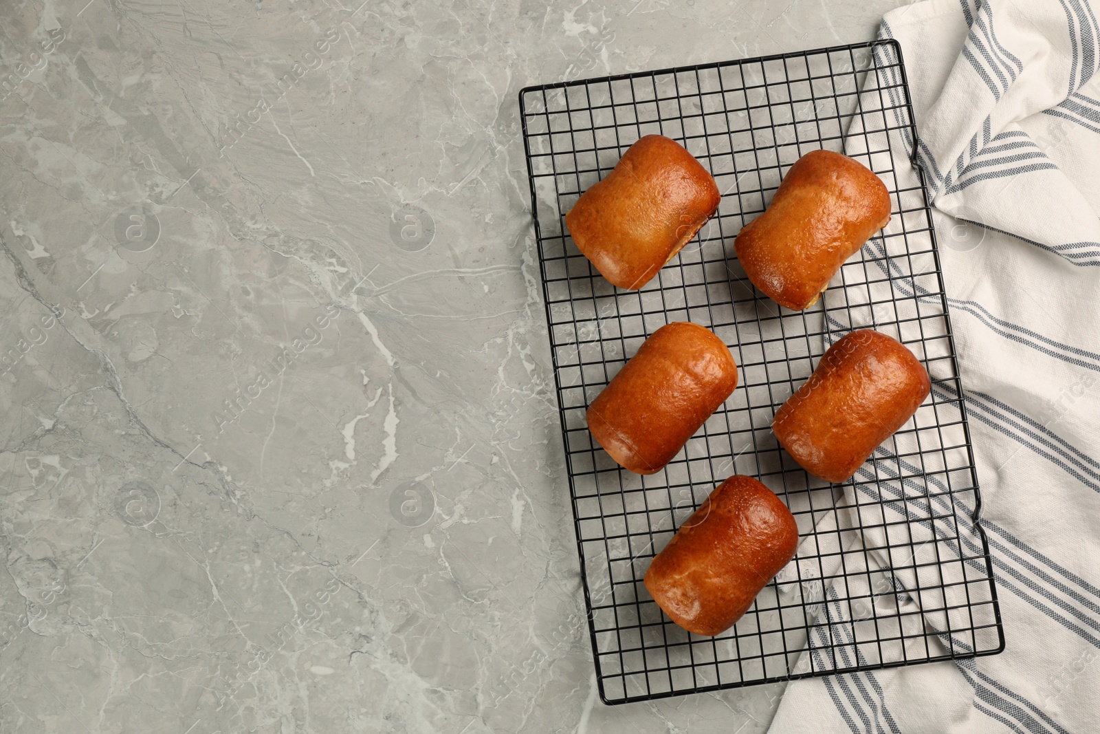 Photo of Delicious baked pirozhki on light grey marble table, top view. Space for text