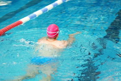 Young athletic man swimming in pool