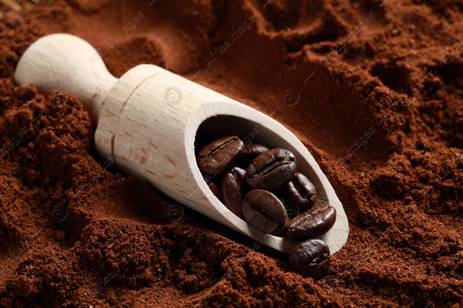 Photo of Scoop with roasted beans on ground coffee, closeup