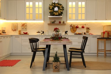 Cozy dining room interior with beautiful Christmas wreath and festive decor