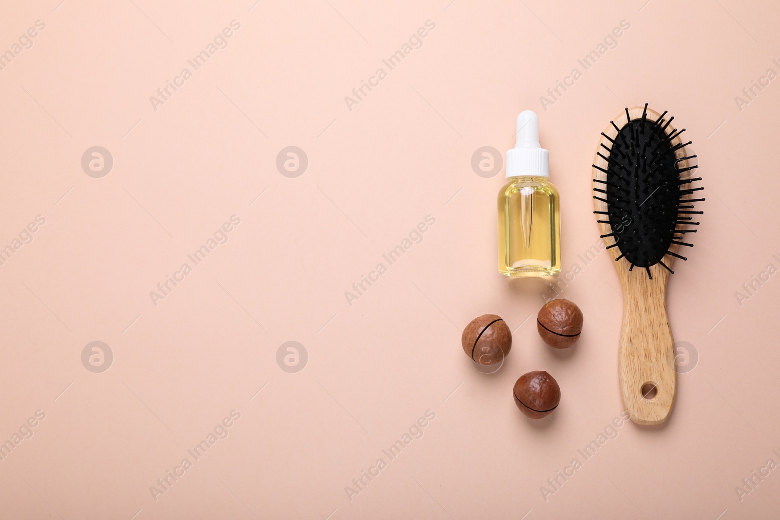 Photo of Delicious organic Macadamia nuts, cosmetic oil and brush on beige background, flat lay. Space for text