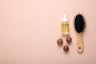 Photo of Delicious organic Macadamia nuts, cosmetic oil and brush on beige background, flat lay. Space for text