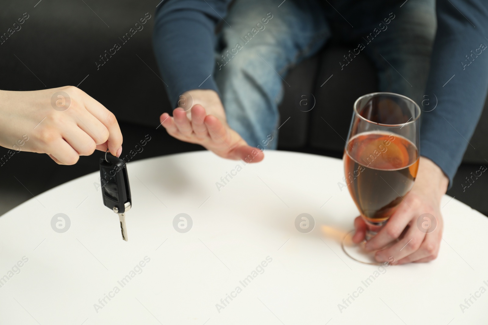 Photo of Man with glass of alcoholic drink refusing drive car while woman suggesting him keys, closeup. Don't drink and drive concept