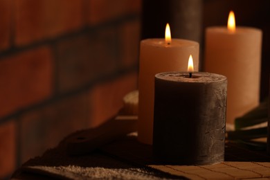 Photo of Spa composition with burning candles on massage table in wellness canter, space for text