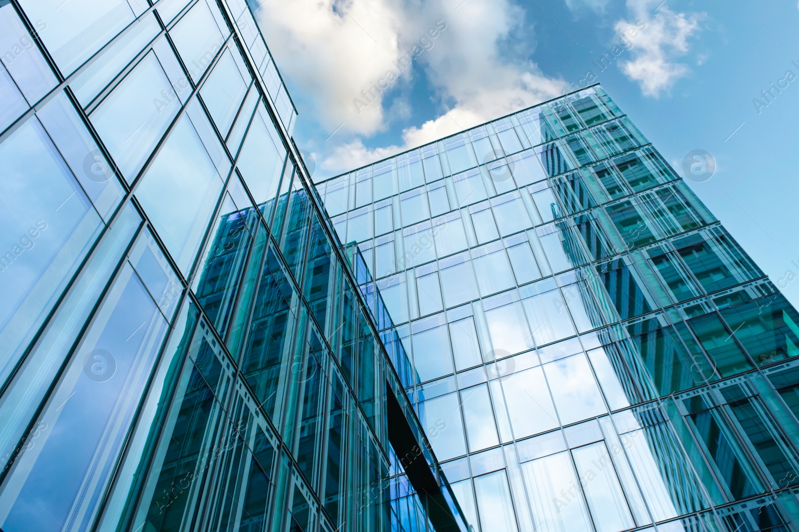 Photo of Stylish buildings with many windows under cloudy sky, low angle view